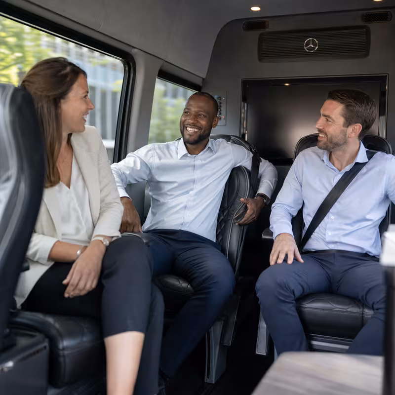 Group boarding a white charter bus for Corporate Transportation transportation in Sterling Heights